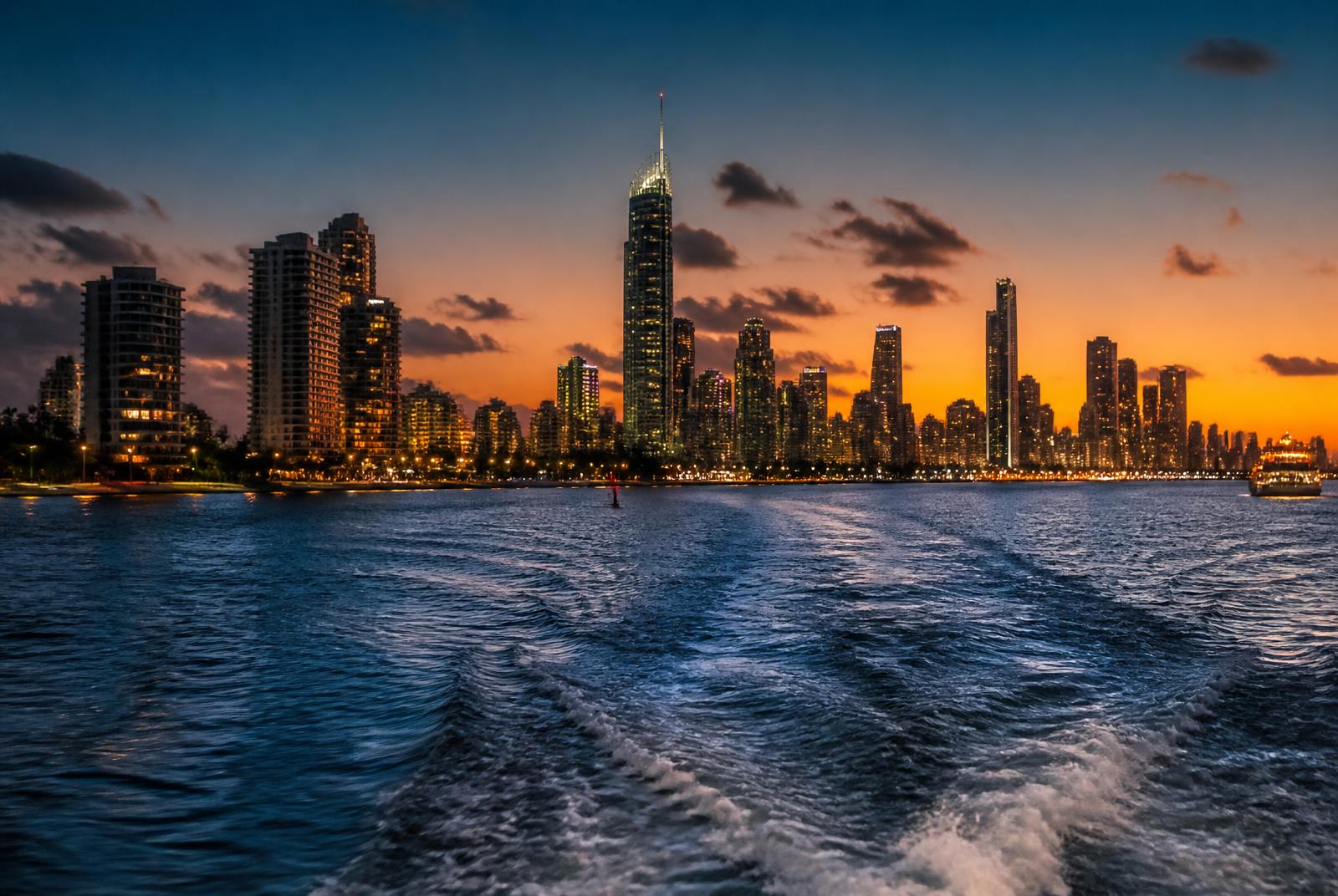 Gold Coast skyline glowing at dusk seen from a boat on the broadwater